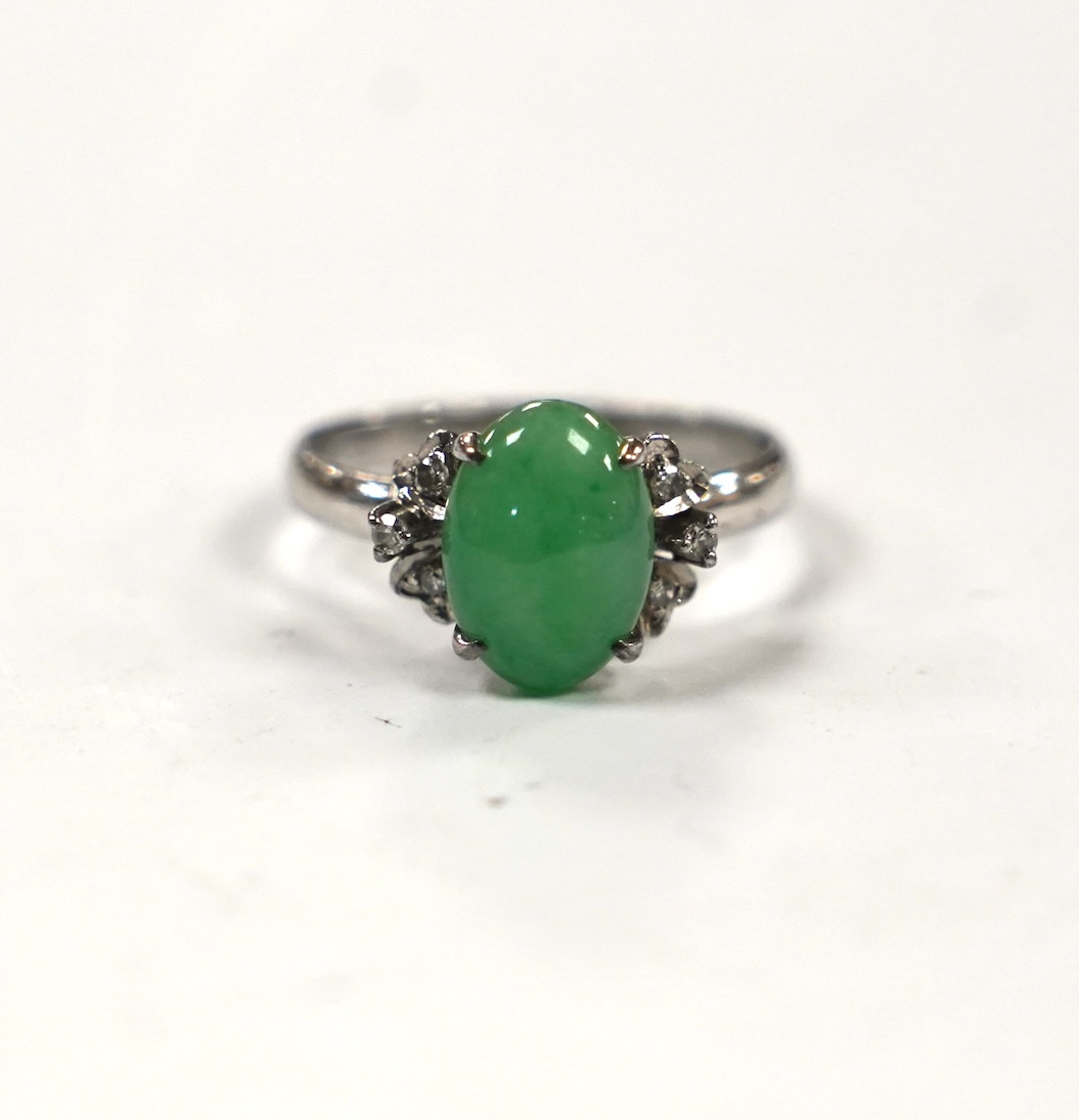 A modern 18k white metal and single stone cabochon jade and six stone diamond chip set ring, size O, gross weight 3 grams.